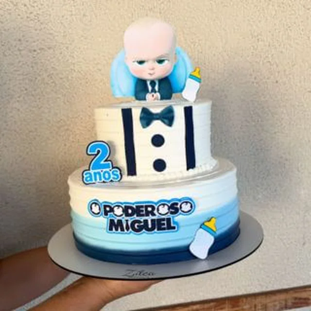 Bolo de dois andares no tema Boss Baby, com boneco no topo