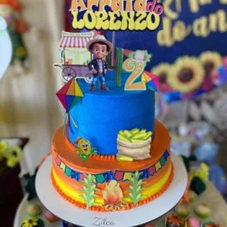 Bolo de dois andares no tema festa junina, com boneco e bandeirinhas