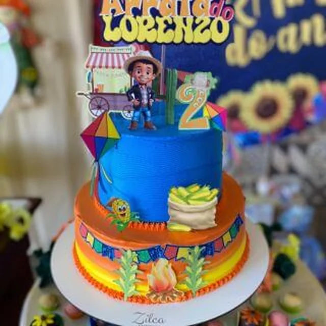 Bolo de dois andares no tema festa junina, com boneco e bandeirinhas