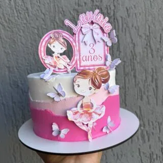 Bolo rosa com topo de papel simples com o nome Lavínia e borboletas