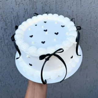 Bolo branco estilo vintage com laços pretos e corações