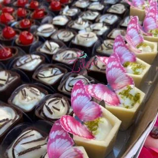 Bandeja de doces finos sortidos em copinhos de chocolate, com aplicação de borboletas
