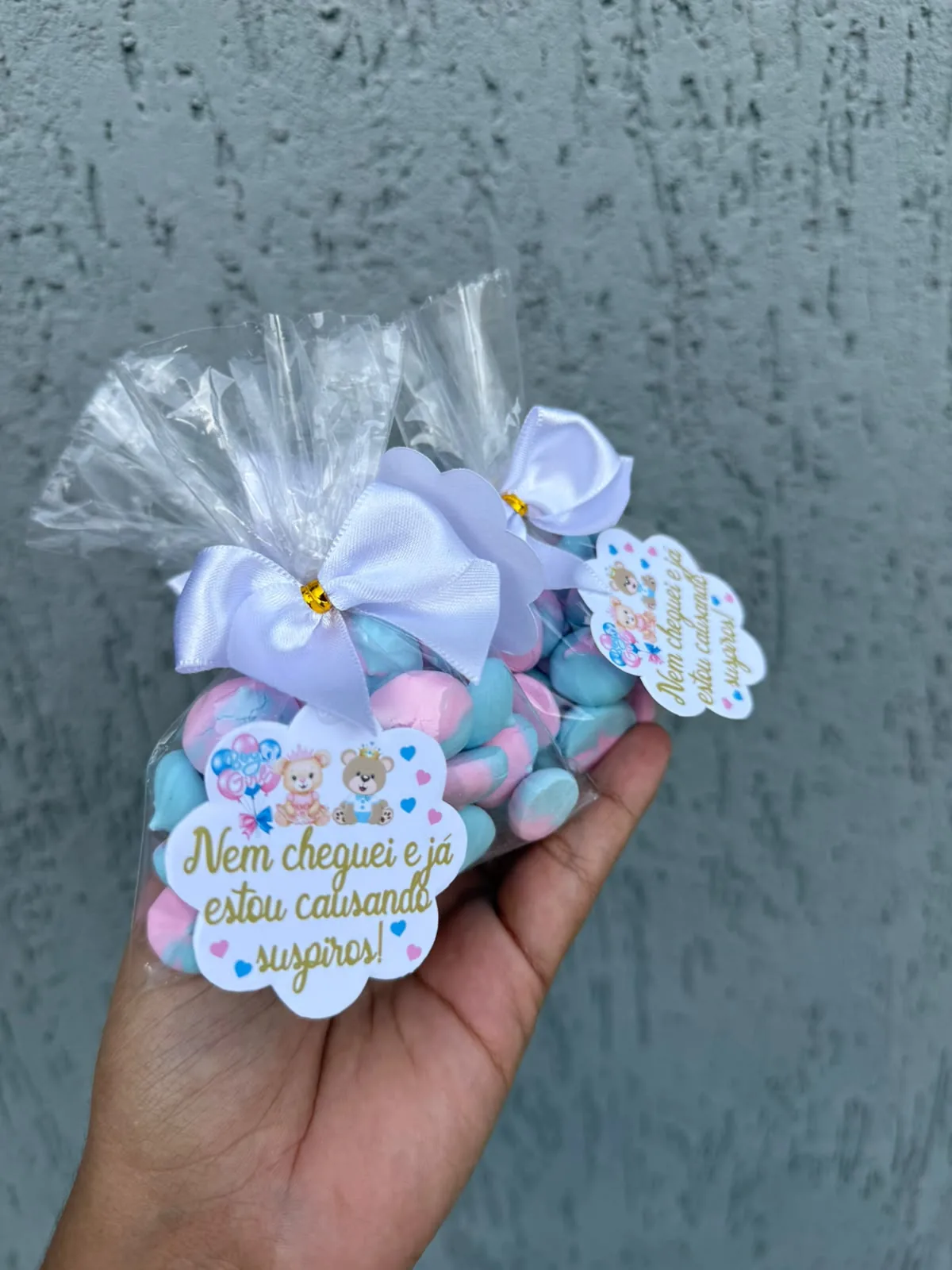 Saquinho de suspiros artesanais rosa e azul, com laço branco e tag personalizada